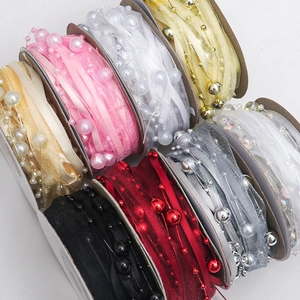 Gros plan de rubans en mousseline colorés avec perles pour emballages cadeaux et bricolage