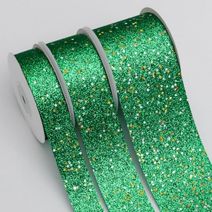 Green glitter ribbon rolls with star sequins for Christmas gift wrapping and DIY crafts