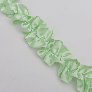 Dettaglio di nastro in raso plissettato verde chiaro per confezioni regalo e artigianato