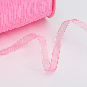 Close-up of bright pink organza ribbon roll with translucent texture for gift wrapping