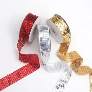Detailed view of red, silver, and gold sequin trim rolls for dance dress decoration
