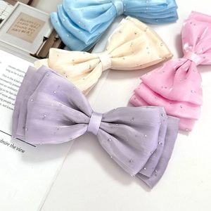 Detail of layered organza bows with rhinestones in purple, pink, beige and light blue