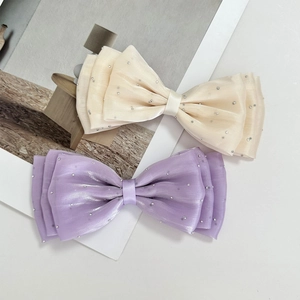 Detail of layered organza bows with sparkling rhinestones in champagne and lavender