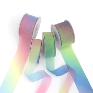 Primo piano di quattro rotoli di nastri in organza arcobaleno per il fai-da-te e regali