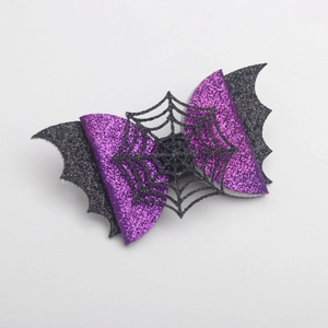 Detail of Halloween bow hair clip featuring purple glitter fabric and black spider web