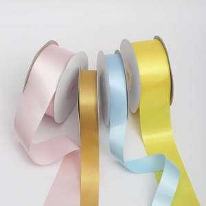 Rolls of colorful satin ribbons for gift wrapping and DIY crafts in pink gold and blue