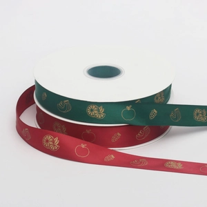 Detail of red and green polyester ribbons with golden fruit patterns for gift wrapping