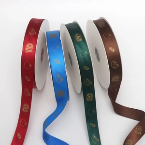 Close-up of four rolls of 2.5cm polyester fruit-themed ribbons with gold foil patterns