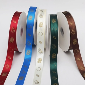 Detailed macro view of five colorful polyester ribbons with gold fruit pattern printing
