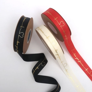 Dettaglio macro di nastri in grosgrain con cuori dorati e scritta Love You Forever
