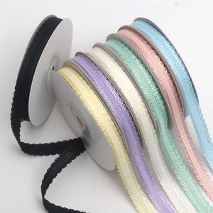 Detail view of colorful wavy edge lace ribbons on white spools for DIY gift packing
