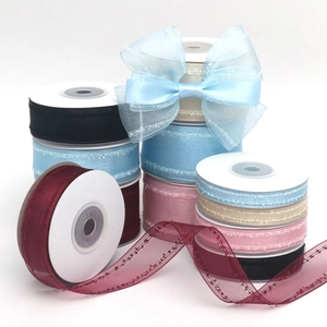 Dettaglio di nastri in organza velata con bordi a pois e fiocco blu fatto a mano per capelli