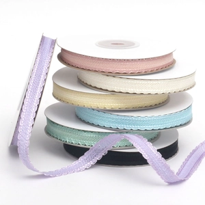 Close-up of colorful wavy lace ribbons on white spools for gift and DIY crafts