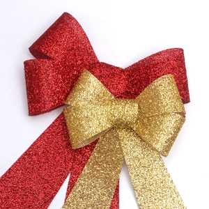 Dettaglio di fiocchi glitterati a doppio strato rosso e oro per regali di Natale