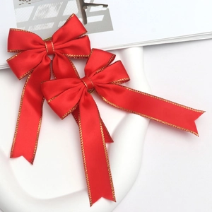 Detail of red satin bows with gold edge stitching for DIY gift box decoration