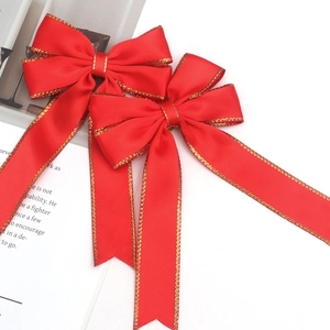 Set of two decorative red satin bows with gold stitched edges for gift wrapping
