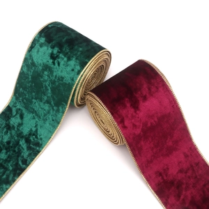Detailed texture of velvet Christmas ribbons in green and burgundy with gold metallic edges