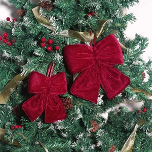 Detail of burgundy velvet Christmas bows in large and small sizes hanging on a tree