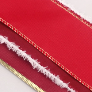 Detailed texture of red Christmas ribbon with white faux fur edges and gold metallic stitching