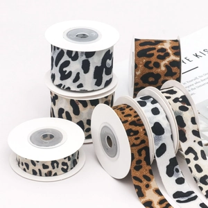 Close-up of leopard print ribbon rolls in various widths for DIY craft and gift wrapping