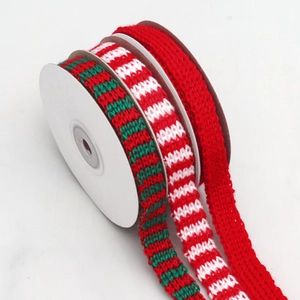 Close-up of festive red and green striped knitted ribbon rolls for gift wrapping and DIY