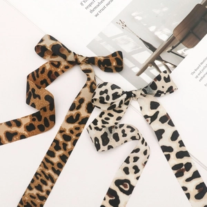 Detail of leopard print twill ribbons showing fabric texture and DIY bow design
