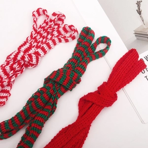 Close-up of three-color knitted mini scarves for dolls in festive red, green and white
