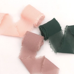 Detail of frayed edge chiffon ribbons in pink, mauve and dark green tones