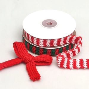 Macro detail of red, white and green knitted ribbons and festive bow for DIY craft