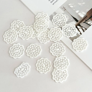 Vue détaillée des délicates appliques florales en coton blanc pour projets de couture DIY