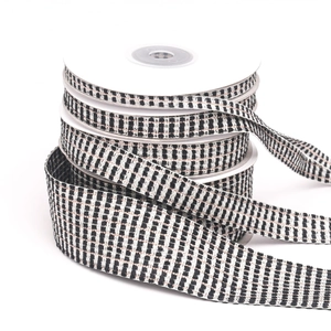 Close-up of black and white checkered ribbon roll with gold metallic woven details