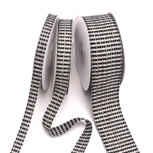 Close-up of three widths of black and white tweed ribbon with elegant gold metallic thread