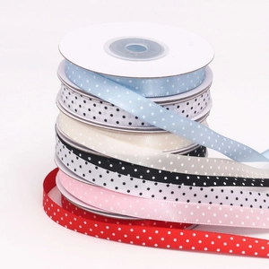 Detailed stacks of 1cm colorful polka dot satin ribbons for DIY gift box packaging