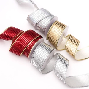 Dettaglio di nastri a scacchi scintillanti in rosso, oro e argento per confezioni regalo