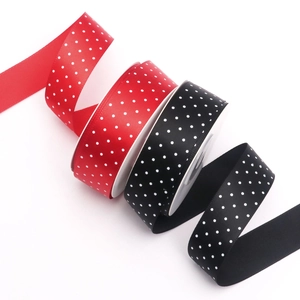 Close-up of 2.5cm red and black polka dot satin ribbons for gift wrapping and DIY crafts