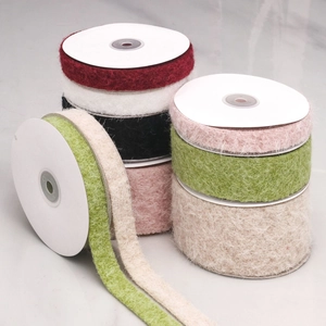 Detail of plush velvet flocking ribbons in various colors on round spools for DIY crafts