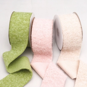 Three rolls of fuzzy mohair velvet ribbons in green, pink, and beige for DIY crafts