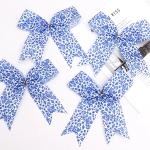 Set di quattro fiocchi in tessuto floreale bianco e blu con fibbie dorate su sfondo bianco