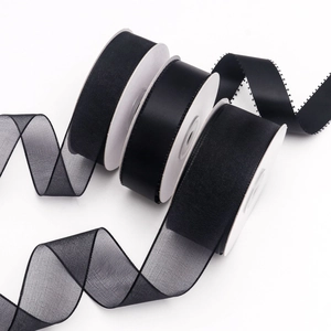 Macro detail of black organza and satin ribbon rolls for DIY gift wrapping accessories
