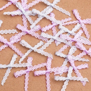Macro view of small lace bows in pink, purple, and white for DIY craft accessories