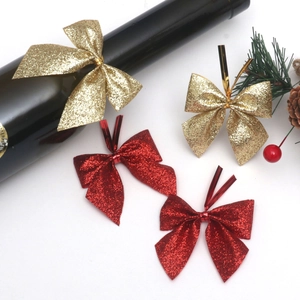 Glitter Christmas bows in red and gold on a festive bottle for holiday tree and gift decor