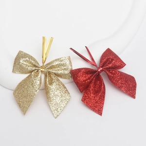 Glittering gold and red Christmas bow ornaments with metallic twist ties for tree decoration