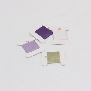 Detail of four-color embroidery threads on plastic bobbins for DIY gift wrapping