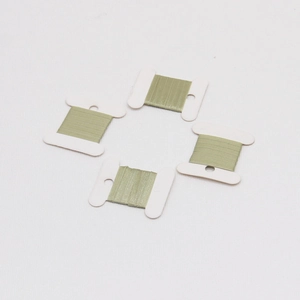 Close-up of four light green sewing thread spools on white plastic bobbins for DIY crafts