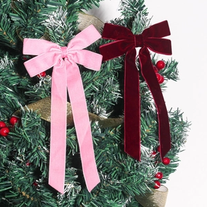 Samt-Weihnachtsschleifen in Rosa und Dunkelrot mit langen Bändern am Weihnachtsbaum