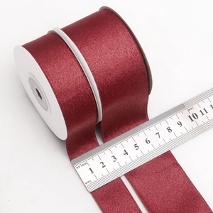 Deep red satin ribbon rolls in 25mm and 50mm widths for DIY gift wrapping and flower decor