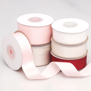Close-up of 4cm silk satin ribbons in pink, white, and red for gift wrapping and DIY crafts