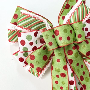 Large Christmas bow with red and green polka dots and white faux fur trim decoration