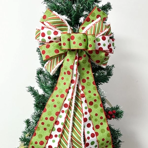 Large Christmas wreath bow with red green polka dots and stripes on a tree branch