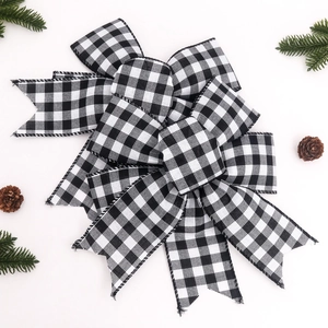 Detail of Christmas buffalo check ribbon bow with pine needles and cones on white background